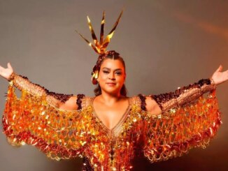 preta gil com roupas de carnaval e de braços abertos